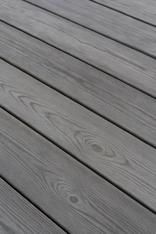 Grånat trädäck där man skymtar ett staket.